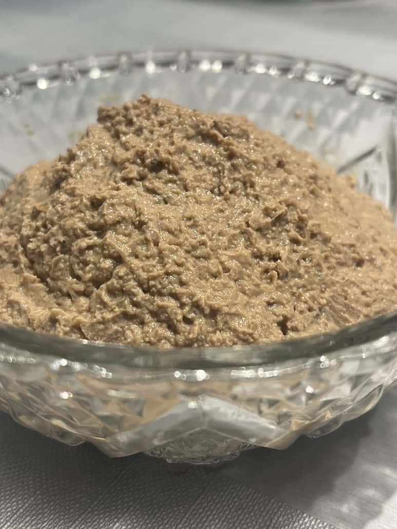 Close-up of classic chopped liver in a clear glass bowl, highlighting the smooth and hearty texture of this homemade spread.