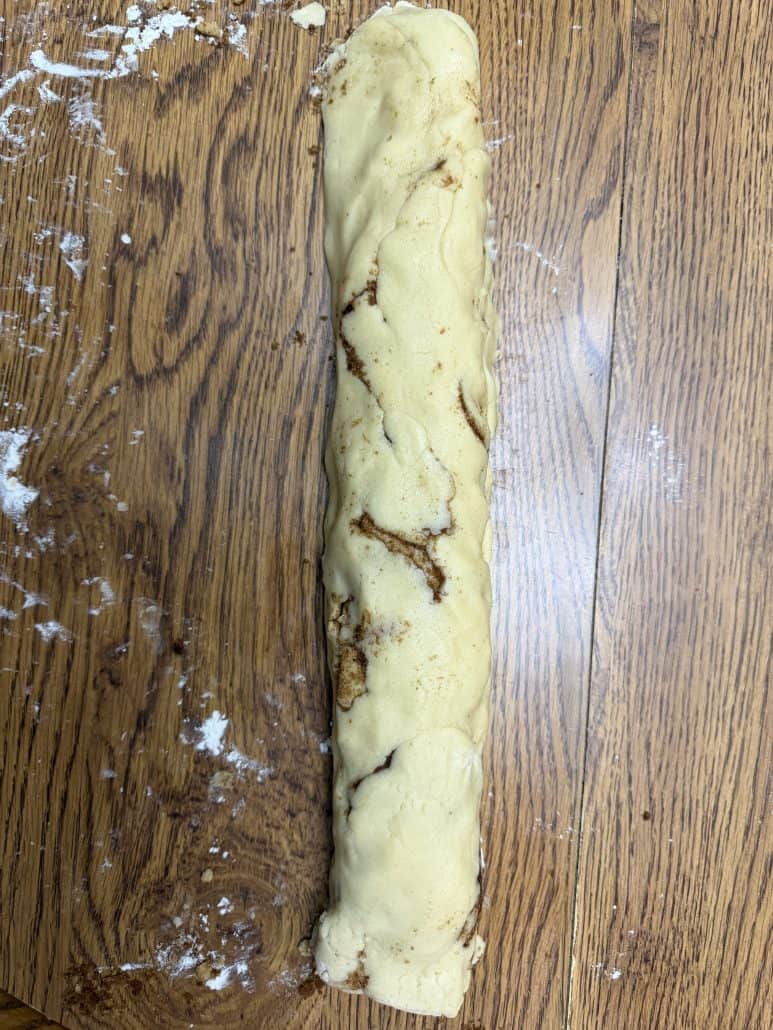 Rolled-up log of cinnamon sugar cookie dough, ready to be sliced into No Chill Cinnamon Roll Cookies.