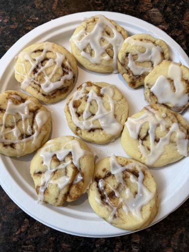 Plate of No Chill Cinnamon Roll Cookies drizzled with glaze, freshly baked and ready to serve.