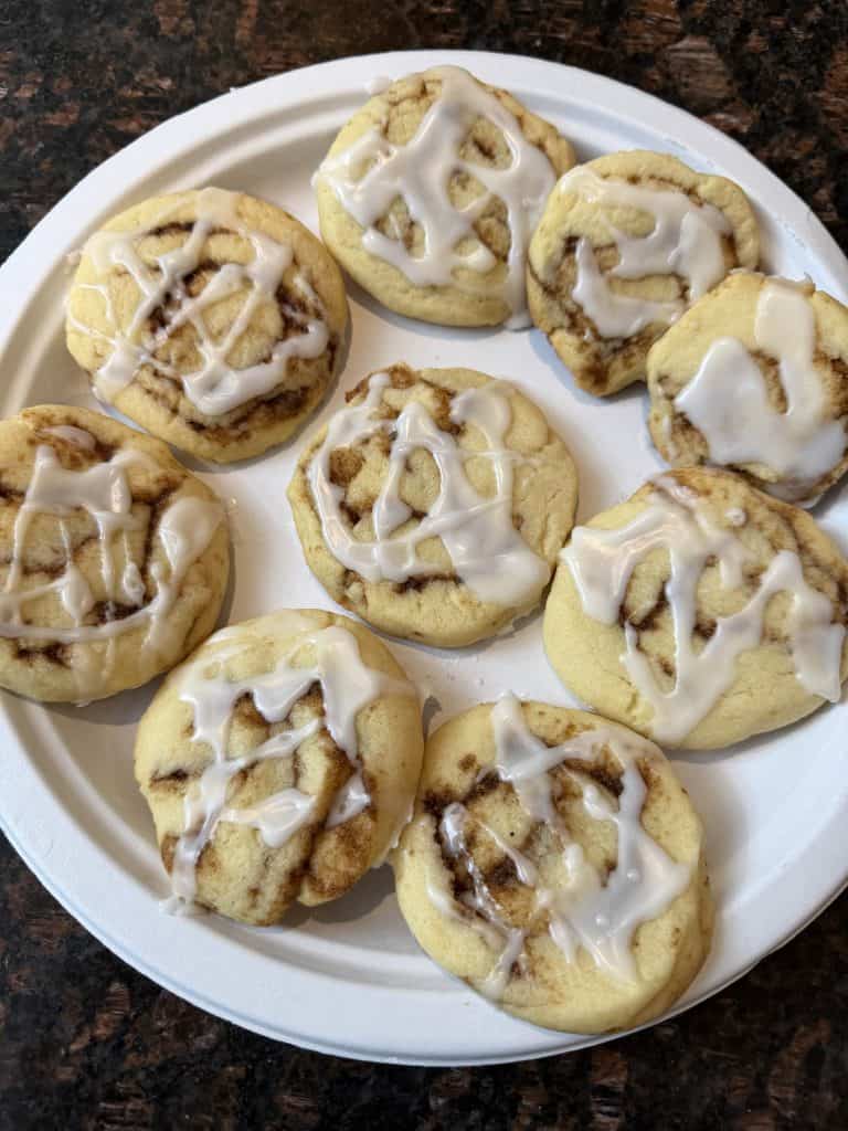 Plate of No Chill Cinnamon Roll Cookies drizzled with glaze, freshly baked and ready to serve.