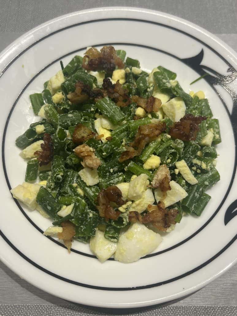 Plate of Green Onion, Egg, and Bacon Salad with chopped eggs, crispy bacon, and fresh green onions mixed together.