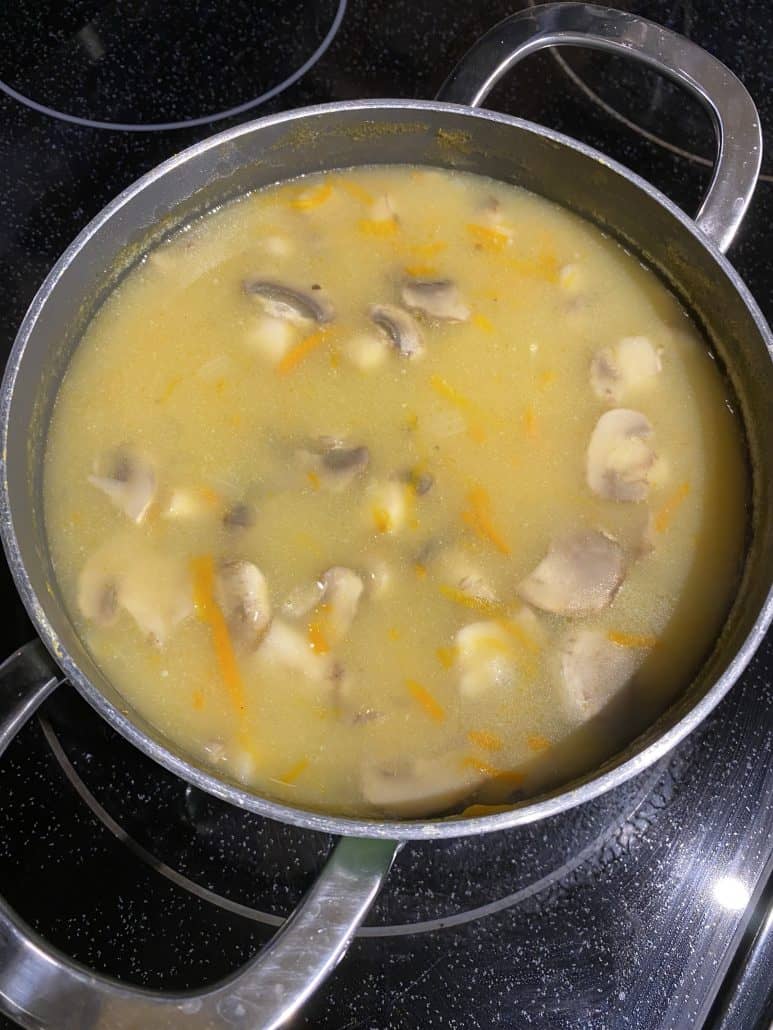 Creamy mushroom soup simmering in a pot, showing chunks of mushrooms, carrots, and potatoes as featured in the Chunky Mushroom Soup recipe.