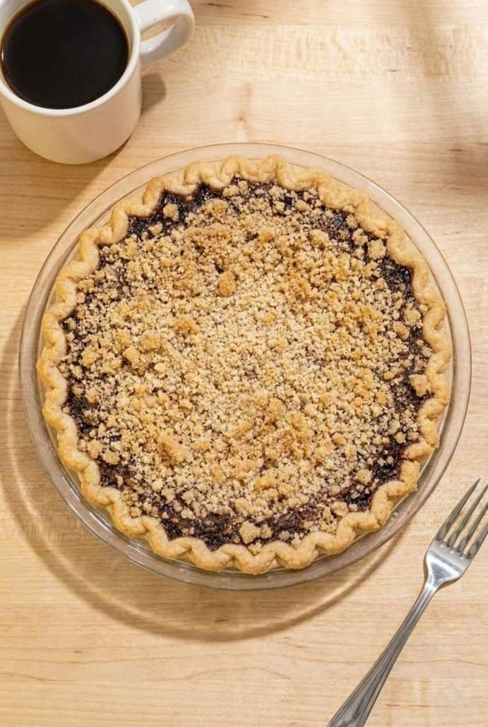 Whole Shoofly Pie with golden crumb topping in a glass pie dish.