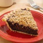 Slice of Shoofly Pie on a red plate with crumb topping, served as a classic dessert.