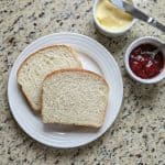 Two slices of homemade Amish white bread on a plate, an easy and delicious way to enjoy this soft, fluffy loaf from the recipe.