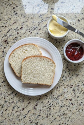 Two slices of homemade Amish white bread on a plate, an easy and delicious way to enjoy this soft, fluffy loaf from the recipe.