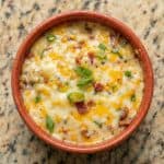 Baked Buffalo Chicken Dip served warm in a round dish, topped with melted cheese and green onions.