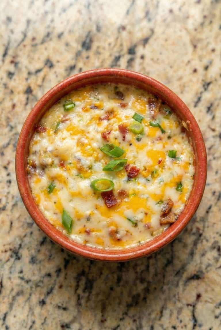 Baked Buffalo Chicken Dip served warm in a round dish, topped with melted cheese and green onions.