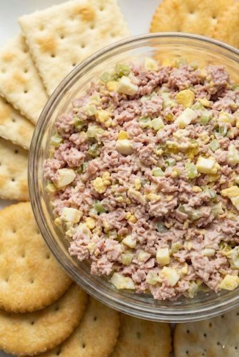 Bowl of creamy ham salad served with round and square crackers. Perfect for snacking, sandwiches, or a quick appetizer.