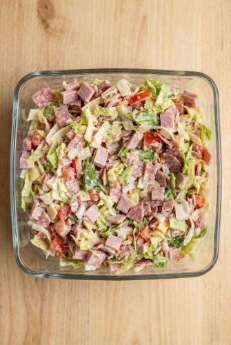 Homemade Hoagie Dip Recipe - Ready In 15 Minutes Bowl of freshly mixed hoagie dip with chopped deli meats, lettuce, and tomatoes.