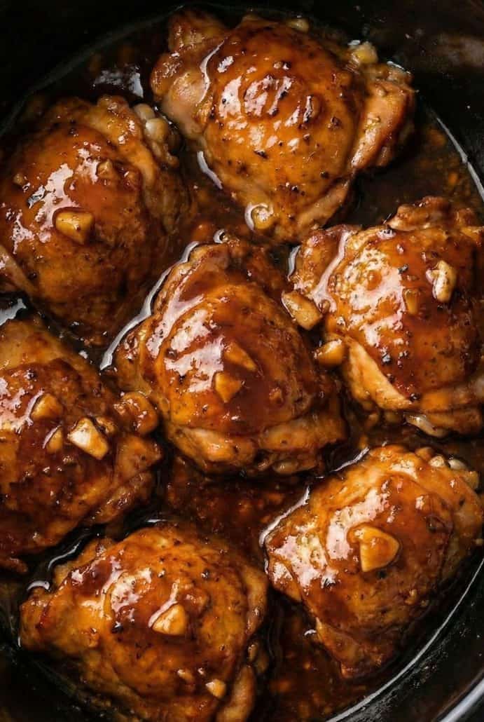 Close-up of juicy honey-garlic chicken thighs simmering in a slow cooker, highlighting the rich, sticky sauce from the Honey-Garlic Slow Cooker Chicken Thighs recipe.