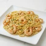 Plate of shrimp scampi with linguine pasta, garnished with parsley. A delicious seafood dinner.