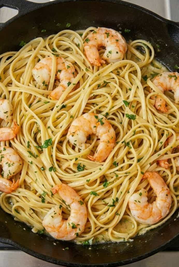 Close-up of shrimp scampi with linguine in a skillet, coated in garlic butter sauce from the easy Shrimp Scampi with Pasta recipe.