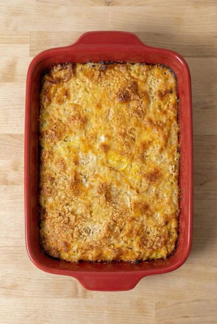 Golden baked squash casserole in a red dish, fresh from the oven. Perfectly crispy on top and ready to serve.