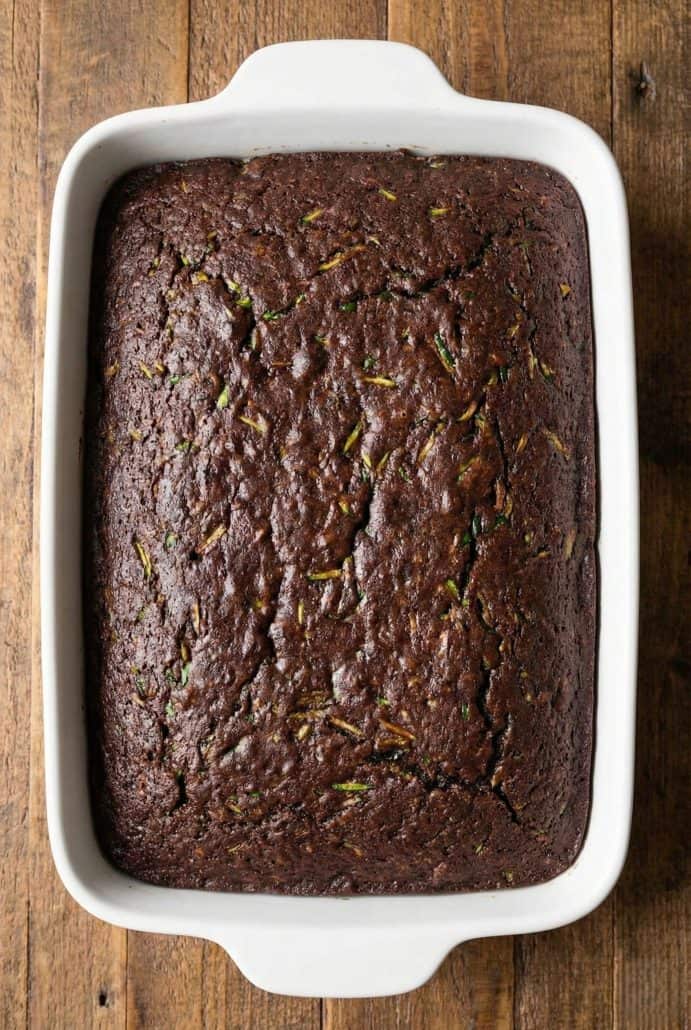 Freshly baked chocolate zucchini cake in a white rectangular baking dish.