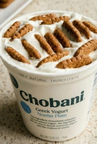 2 Ingredient Japanese Cheesecake – Viral TikTok Recipe Chobani plain Greek yogurt tub topped with Biscoff cookies pressed into the yogurt.
