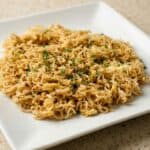 Close-up of finished TikTok Ramen with egg and chopped green onions served on a white plate.