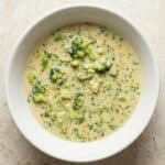Creamy homemade broccoli cheese soup served in a white bowl, highlighting the rich, cheesy texture.