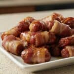 Bacon-wrapped little smokies coated in caramelized brown sugar glaze, served as an easy sweet and savory party appetizer.