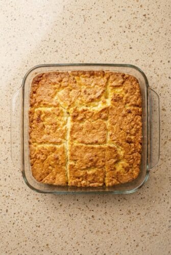 Butter Swim Biscuits – Fluffy, Golden & Incredibly Easy! Golden brown butter swim biscuits baked in a square dish and cut into nine pieces, showing the crispy edges and fluffy texture.