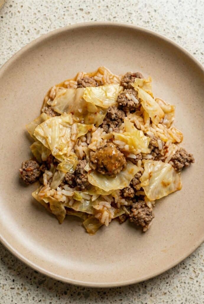 Plated serving of cabbage roll casserole showing tender cooked cabbage, seasoned ground beef, and rice in rich tomato sauce, featured in this easy baked comfort food recipe.