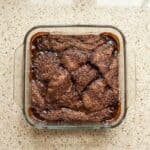 Overhead view of freshly baked chocolate cobbler in a square baking dish, showing the crackly cake-like top and rich, gooey chocolate sauce underneath.