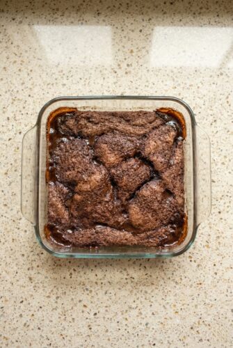 Easy Chocolate Cobbler Recipe – Warm, Fudgy & Irresistible Overhead view of freshly baked chocolate cobbler in a square baking dish, showing the crackly cake-like top and rich, gooey chocolate sauce underneath.