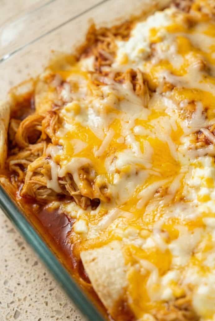 Close-up of creamy Cottage Cheese Chicken Enchiladas topped with melted Monterey Jack cheese and red enchilada sauce, baked until hot and bubbly for this easy family dinner.