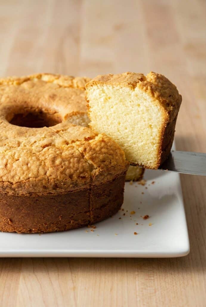 Sliced cream cheese pound cake on a plate, showcasing its light, dense texture.