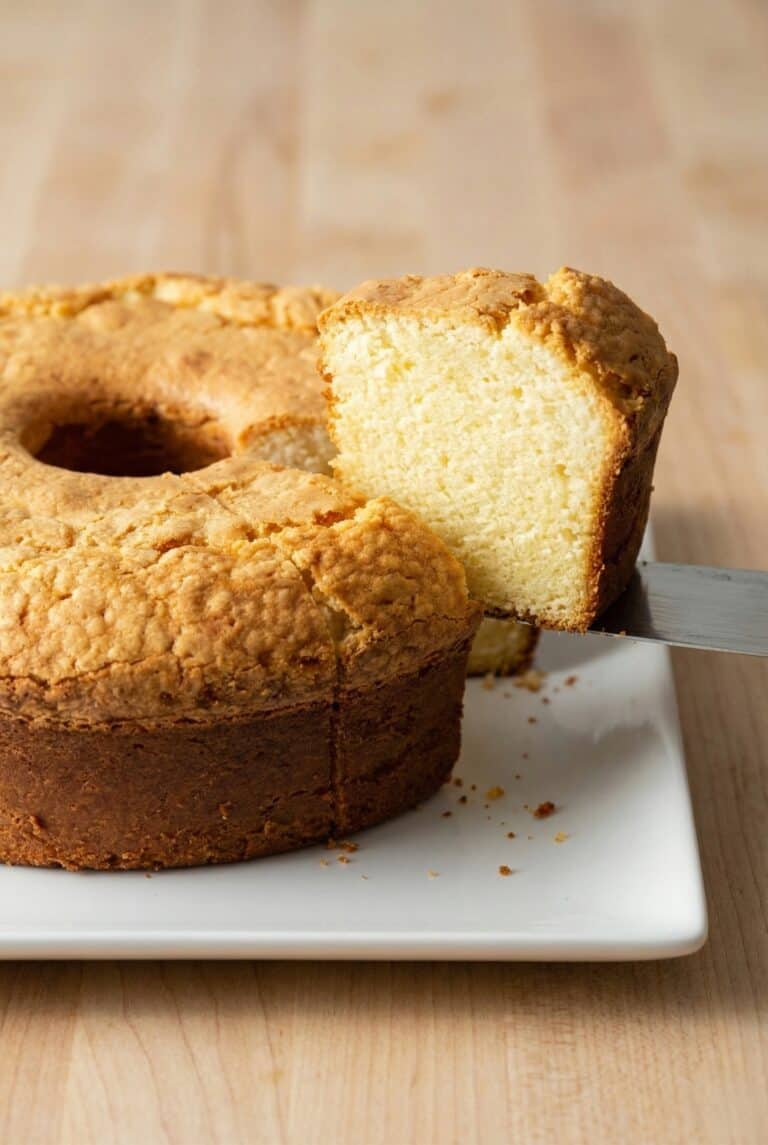 Sliced cream cheese pound cake on a plate, showcasing its light, dense texture.