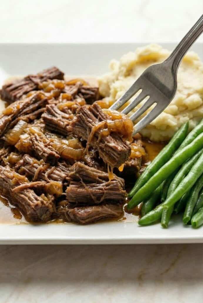 Close-up of tender Georgia pot roast being lifted with a fork.