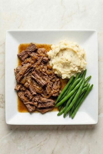 Slow Cooker Georgia Pot Roast Recipe Georgia pot roast with mashed potatoes and green beans, showing tender shredded beef in rich gravy.