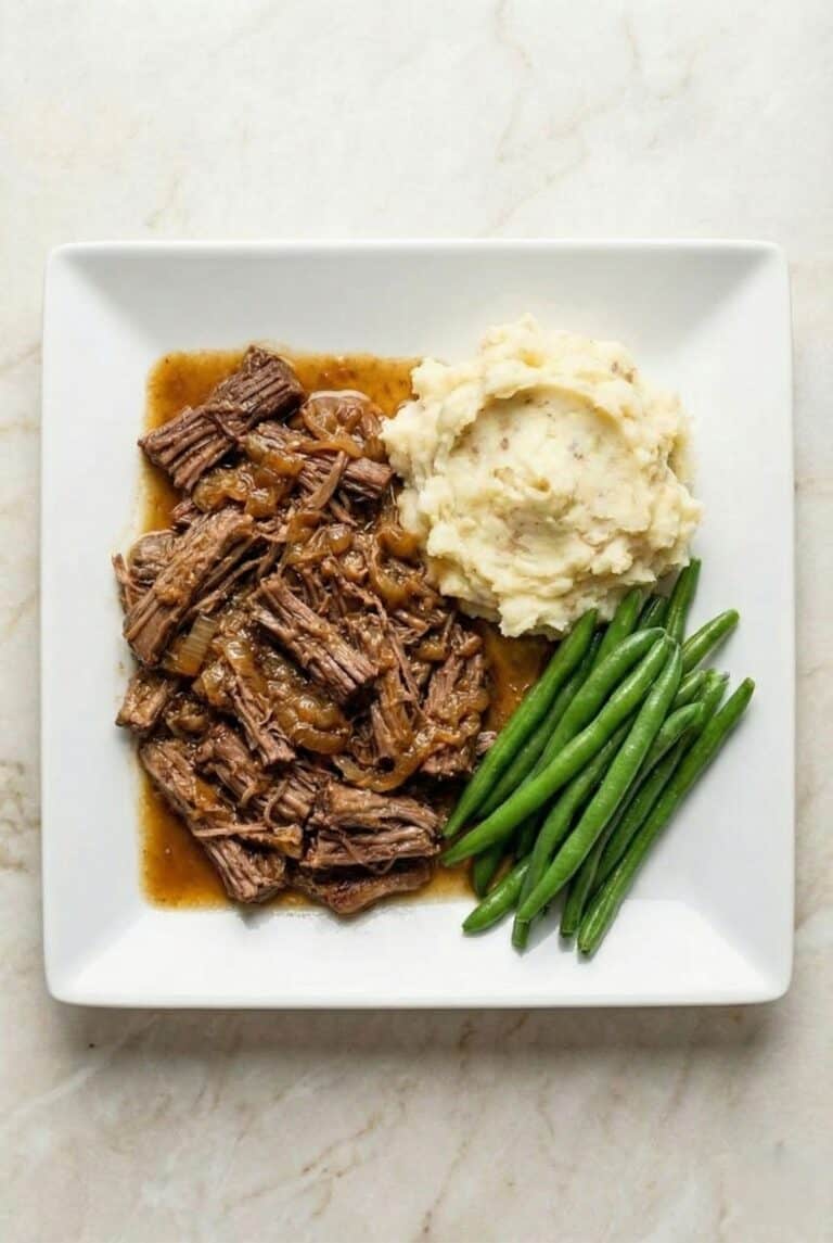Georgia pot roast with mashed potatoes and green beans, showing tender shredded beef in rich gravy.