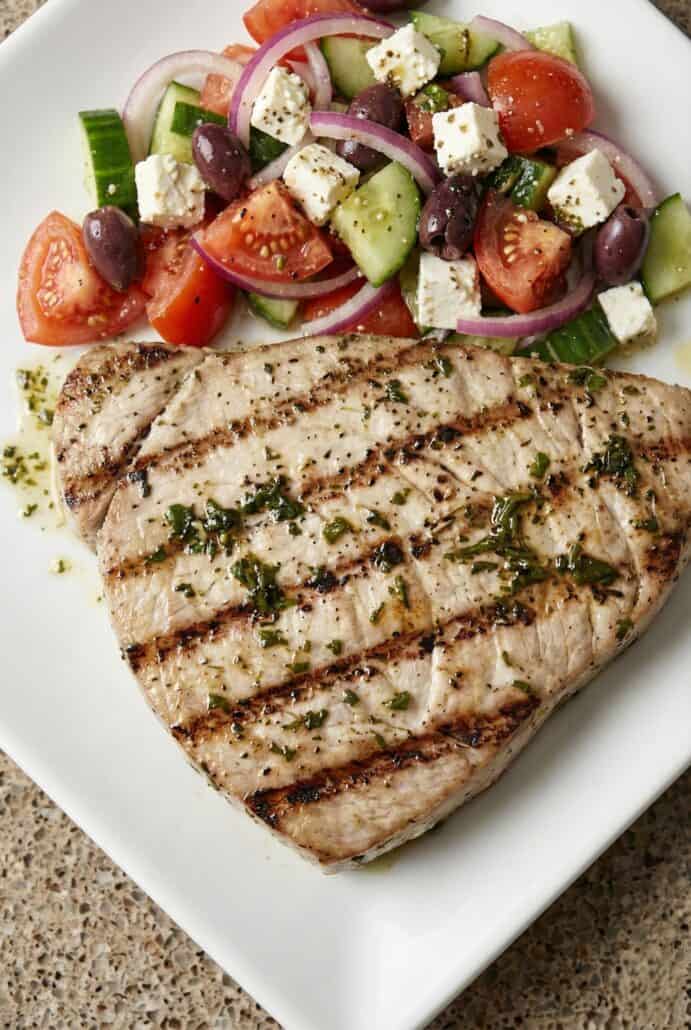 Close-up of grilled marinated tuna steak with defined grill marks.