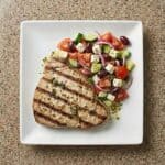 Grilled marinated tuna steaks served with a fresh tomato and avocado salad.
