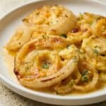 Close-up of cheesy Tennessee Onions casserole with tender baked onion rings layered in melted cheddar and herbs.
