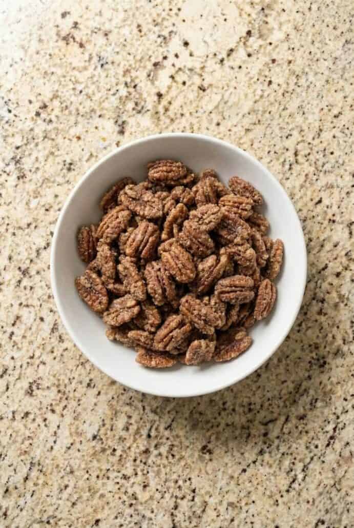 Top view of a bowl of cinnamon sugar pecans, featured in this easy Texas glazed pecans.
