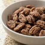 Bowl of cinnamon glazed pecans, shown as a sweet and crunchy Texas candied pecan recipe.