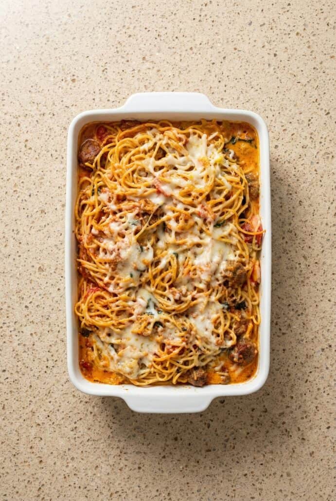 Freshly baked TikTok spaghetti casserole in a white dish, straight from the oven and loaded with melted cheese and meat sauce.