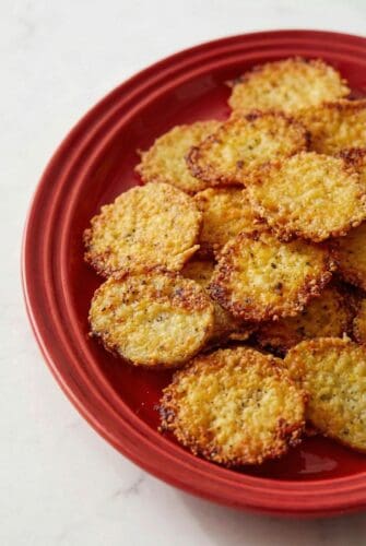 Easy Parmesan Crusted Potatoes - Viral TikTok Recipe Crispy parmesan crusted roasted potatoes served on a red plate. A delicious and golden appetizer.