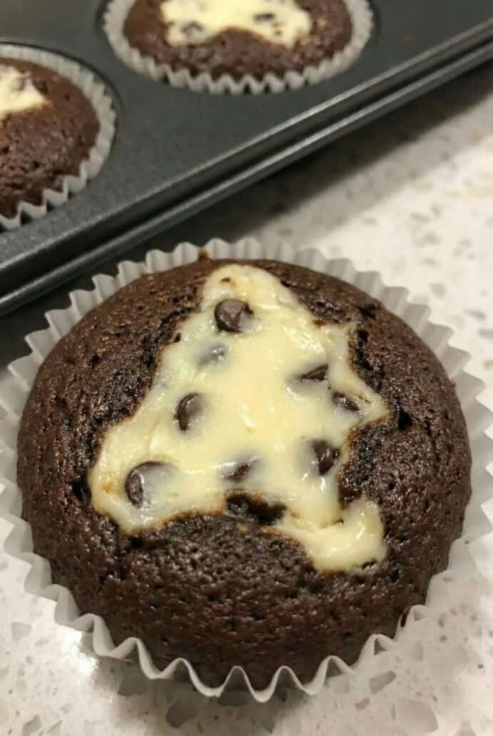Close-up of a freshly baked Black Bottom Cupcake with a creamy, chocolate chip-filled center.