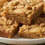 Chewy peanut butter brownies cut into squares and topped with peanut butter chips, shown on a plate to illustrate the soft texture and rich peanut butter flavor.