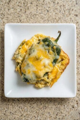 Cheesy Chile Relleno Casserole | Easy Weeknight Dinner Recipe Cheesy chili relleno casserole made with poblano peppers and melted cheese, served on a white plate.