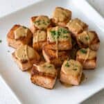 Crispy bang bang salmon bites drizzled with creamy sauce.