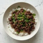 Korean beef bowl with ground beef over rice, garnished with green onions, featured in this easy 25-minute dinner recipe.