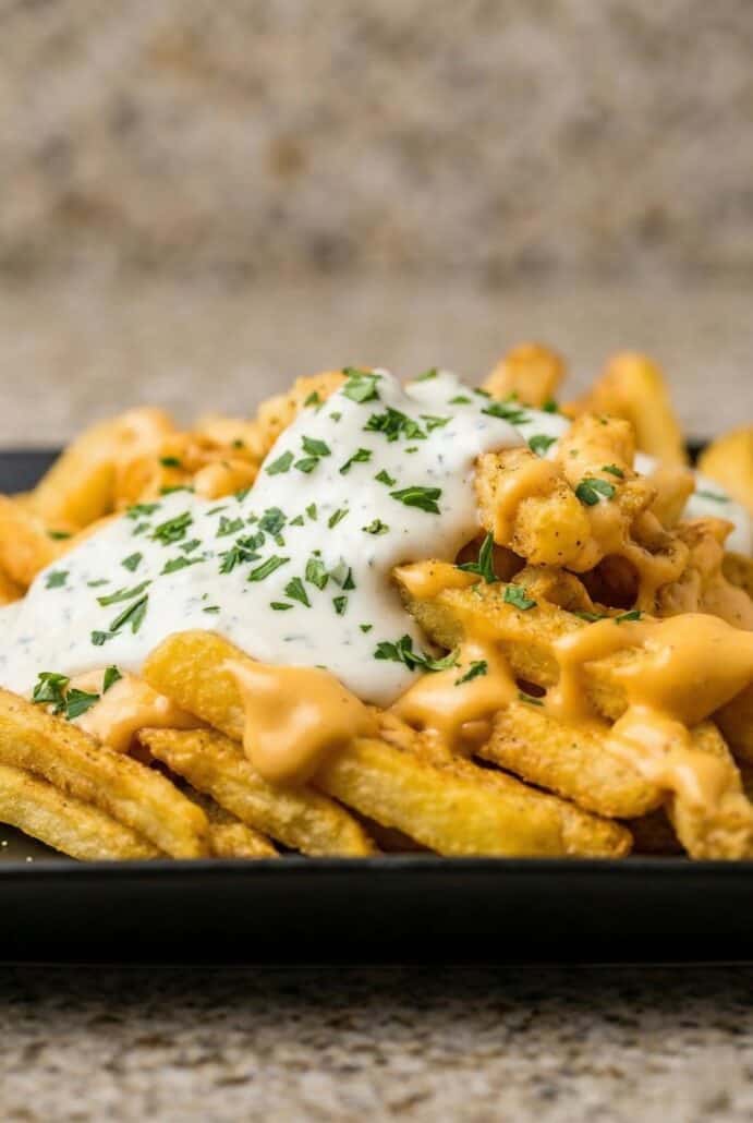 Louisiana Voodoo fries topped with creamy cheese sauce, ranch drizzle, and seasoning.