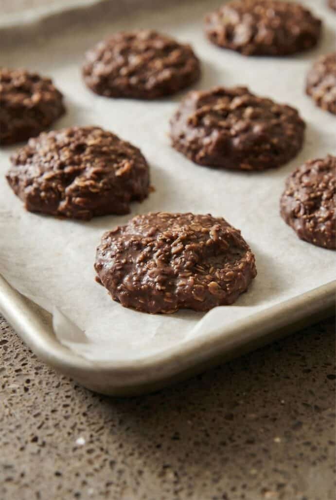 Close-up of homemade no-bake chocolate oatmeal cookies with peanut butter and cocoa on a plate, showing the chewy texture.