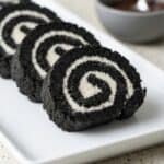 Close-up of Oreo sushi rolls with a spiral cream center on a plate, showcasing a fun and easy no-bake cookies and cream dessert.