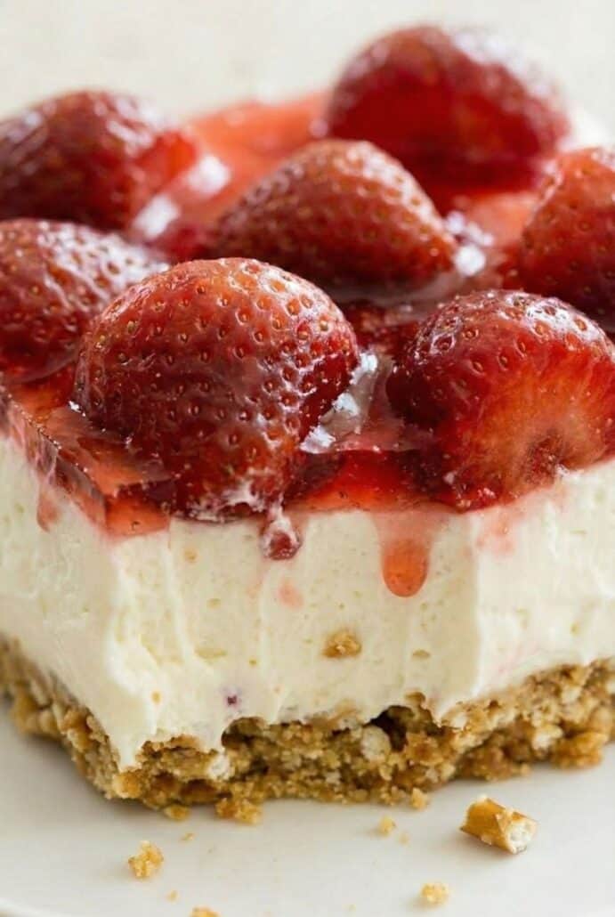 Close-up of strawberry pretzel salad highlighting the juicy strawberry topping over the smooth cream cheese layer and crunchy pretzel crust.