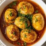 Spicy TikTok egg boil with buttery Cajun sauce, featuring boiled eggs coated in rich garlic seasoning for an easy high-protein meal.